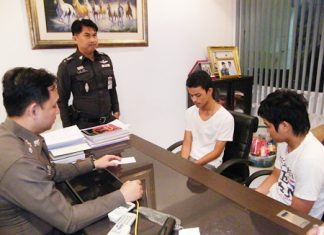 Thanawat Pornjit-udom and Pirapong Boonkor turn themselves in at Pattaya Police Station.